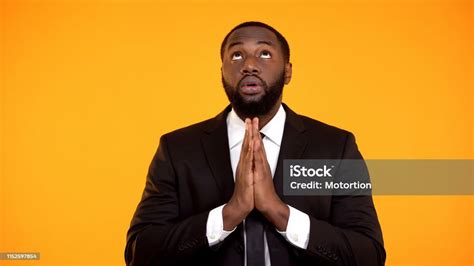 Africanamerican Male In Suit Praying And Looking Up Faith Asking For