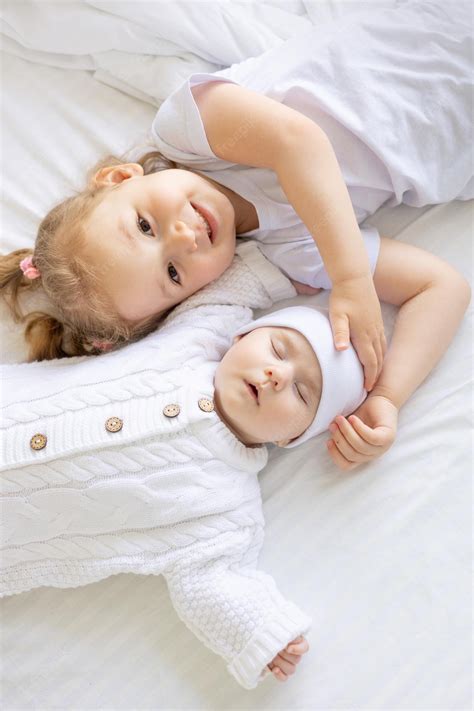 Una Niña Abraza A Una Hermana O Hermano Recién Nacido Dormido En Una