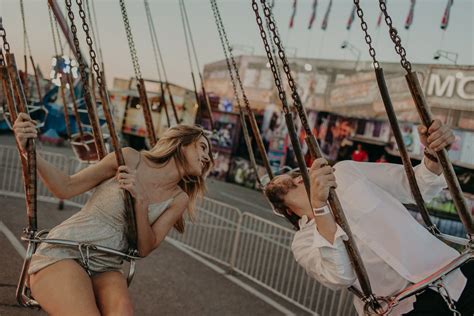 The Couple Swings Together At A Carnival For Their Engagement Photos In Chattanooga Tennessee