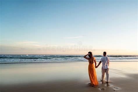 Romantic Couple Walking On Sunset Beach Enjoying Evening Light Relaxing On Tropical Summer