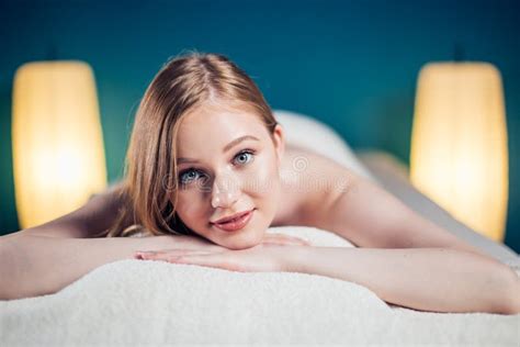 Young Beautiful Woman In Spa Salon Lying On Massage Table Waiting For