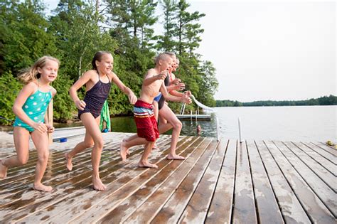 Children Jumping Into Lake Stock Photo Download Image Now Istock