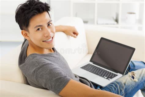 Young Man Sitting In Sofa And Using Laptop Stock Photo Image Of