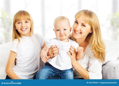 Familia Feliz En Casa En El Sofá Madre E Hija E Hijo Foto De Archivo