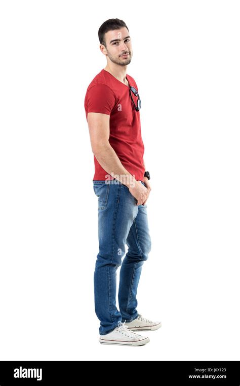 Side View Of Young Relaxed Casual Man In Red T Shirt And Jeans Looking