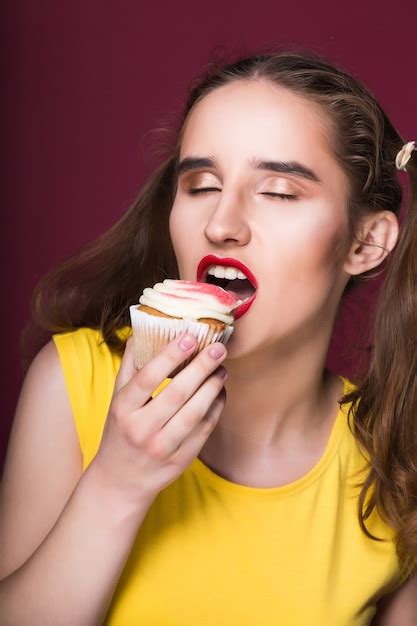 Premium Photo Hungry Brunette Model Biting Yummy Cake With Cream Over