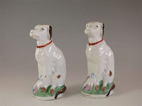 Two Ceramic Dogs Sitting Next To Each Other