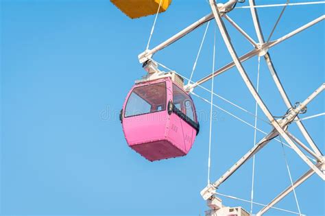 Colorful Ferris Wheel In An Amusement Park Against Blue Sky Stock Photo