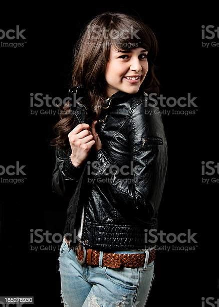 Portrait Of Beautiful Teenage Girl Wearing Leather Jacket On Black