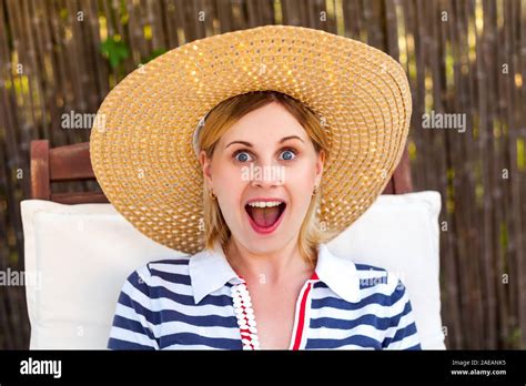 Closeup Portrait Of Happy Laughing Unexpectedly Young Adult Woman In Hat And Dress Sitting On