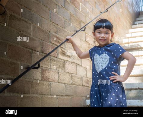 Cute Small Asian Small Girl Posing At Stair While On Vacation Stock
