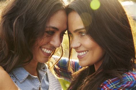 Lesbian Couple Embrace Outdoors Look To Each Other Close Up Stock