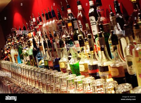 Row Of Alcoholic Drink Bottles And Spirits Behind A Bar With Glasses
