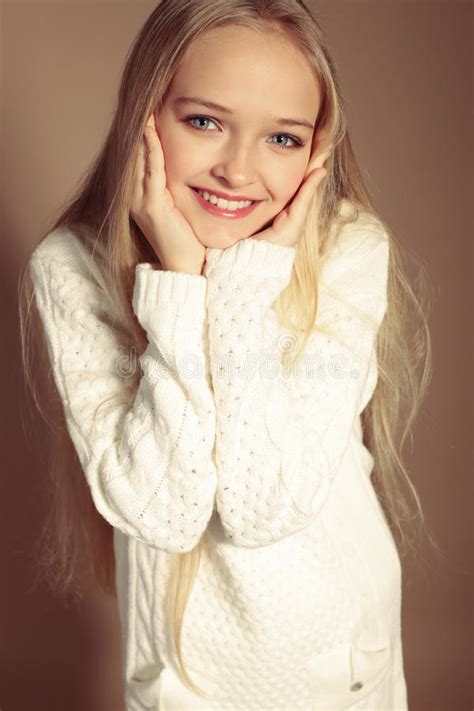 Beautiful Little Girl With Long Blond Hair In Cozy Knitted Clothes