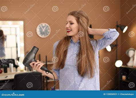 Professional Hairdresser With Blow Dryer In Beauty Salon Stock Image