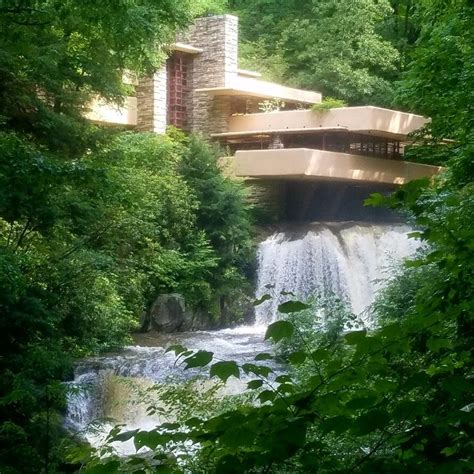 A House In The Woods With A Waterfall Coming Out Of Its Center Window