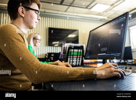 Engineer Designer Working On Desktop Computer In Factory Stock Photo