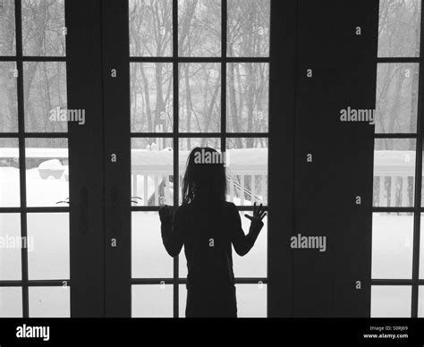 Girl Looking Out Window At Snow Stock Photo Alamy