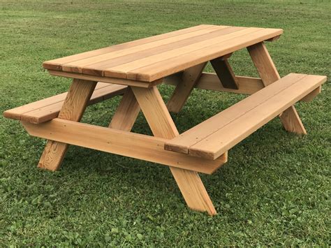 Red folded tablecloth over bleached wooden table. 48" Kids Picnic Table. Easy to move, seats 6 children. 48" Long