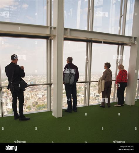 Two Men And Two Women Looking At The View From The Top Viewing Floor Of