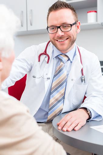 Doctor Seeing Senior Patient In Practice Stock Photo Download Image