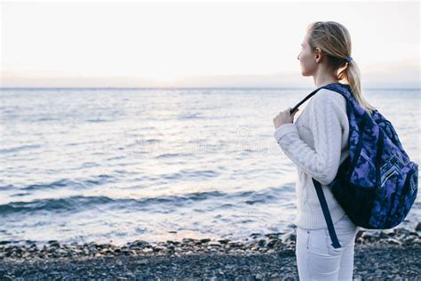 Woman Traveler In A White Clothing Standing On The Shore And Looks At