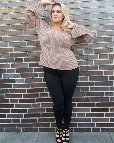 A Woman Posing In Front Of A Brick Wall