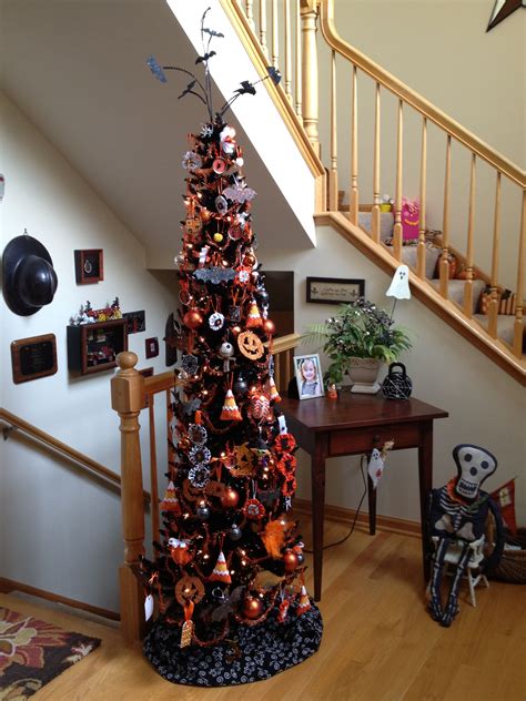 A Decorated Christmas Tree In The Corner Of A Room Next To A Stair Case