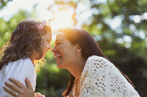 Enthusiastic Mother And Daughter Smiling Face To Face Stock Photo