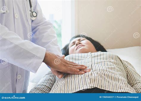 Doctor Examining Stomach Of Woman Patient And Pressing Hands On Her