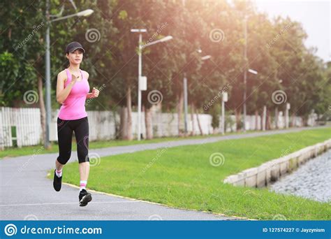 Sporty Female Jogger Morning Exercise On Seaside In The Park Stock