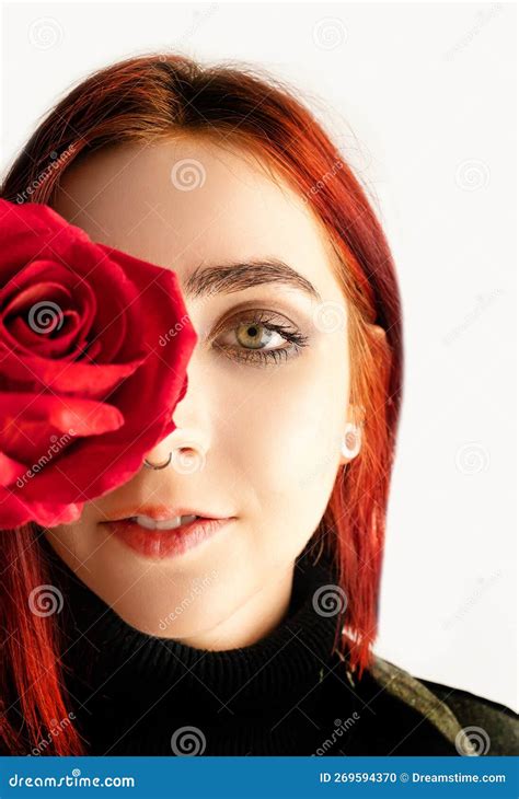 Portrait Of A Young Beautiful Woman Holding A Red Rose In Her Hand