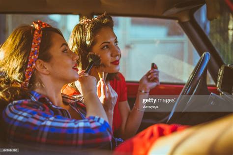 Happy Pinup Girls Driving Vintage Car And Applying Makeup High Res