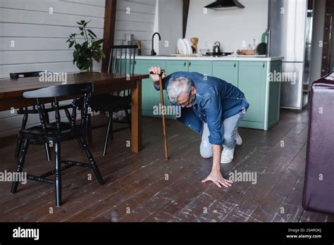 Elderly Man With Crutch Falling On Floor At Home Stock Photo Alamy