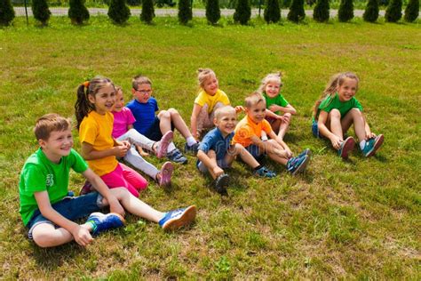 Close View Of Smiling Kids Sitting On A Lawn Stock Image Image Of