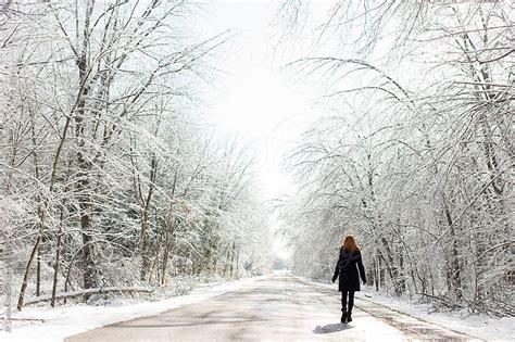 Redhead Woman Walking On Icy Road In Winter With Snow By