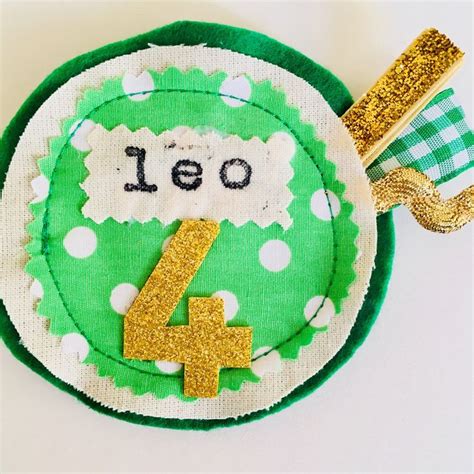 A Green And White Plate With A Number Four On It Next To A Gold Ribbon