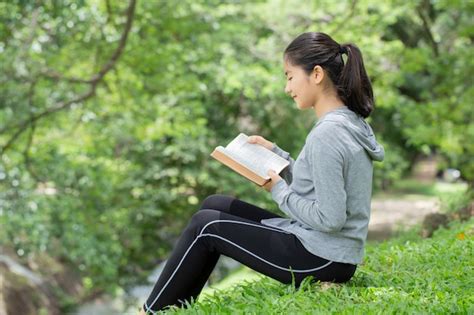 Premium Photo Pretty Young Woman Reading Bible In Park Reading A