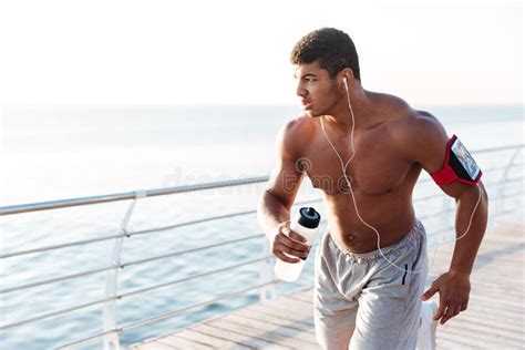 Serious African Sportsman Running And Listening To Music Outdoors Stock