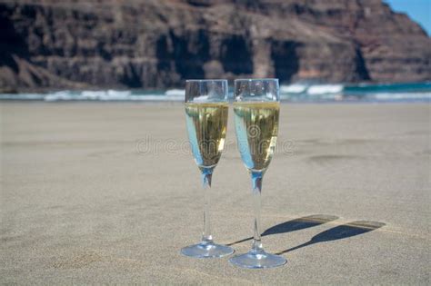 two glasses of champagne or cava sparkling wine served on the white sandy tropical beach luxury