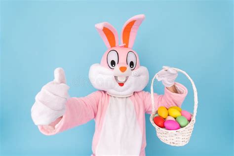 Happy Easter Easter Bunny Or Rabbit Or Hare Holds Egg With Basket Of Colored Eggs Having Fun