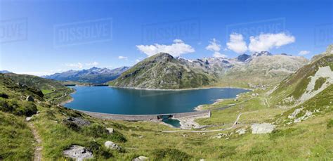 Panorama Of The Blue Lake Montespluga Surrounded By Rocky Peaks In