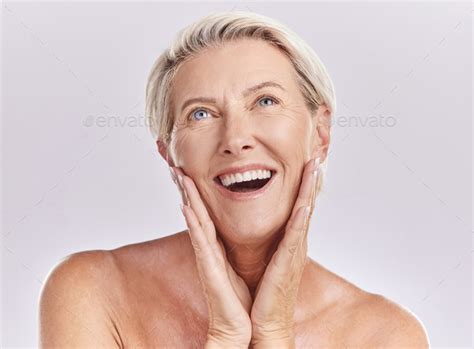 beautiful mature caucasian woman posing topless and isolated against a pink background copyspace