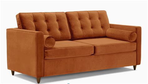 An Orange Couch Sitting On Top Of A White Floor