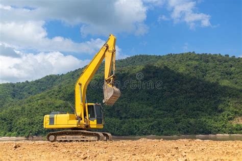 Excavador En Sitio Del Material De Construcción En Fondo Del Río Y De