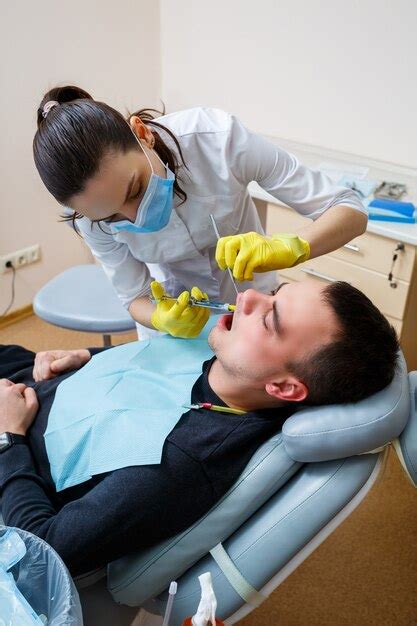 El Dentista Inyecta Al Paciente En La Encía Para Anestesiar Los Dientes