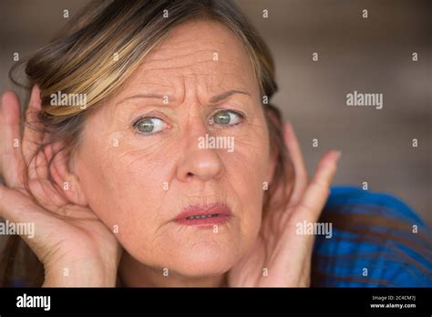 Portrait Attractive Mature Woman With Hands At Ears Listening With