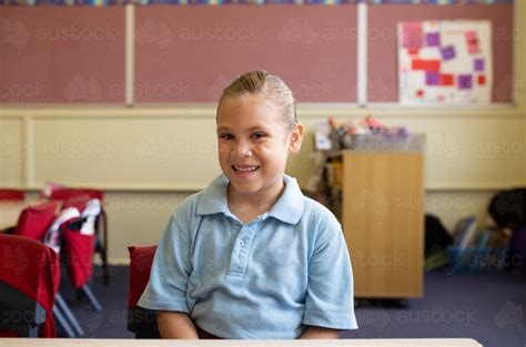 Image Of Female Primary School Student Sitting Smiling In A Classroom