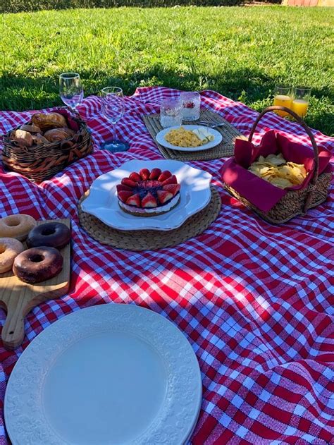 A Picnic Table With Plates And Bowls Of Food On It Including Doughnuts
