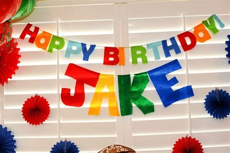 A Happy Birthday Cake Banner With Red White And Blue Paper Fans On